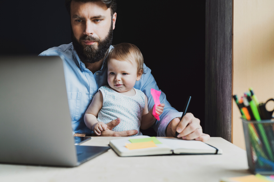 ein Vater sitzt mit seinem Baby auf dem Schoß vor einem Laptop, um zu lernen - als Bild für eLearning von TOP Training - Training - Online - Professionell - von ITSM Partner in Wien